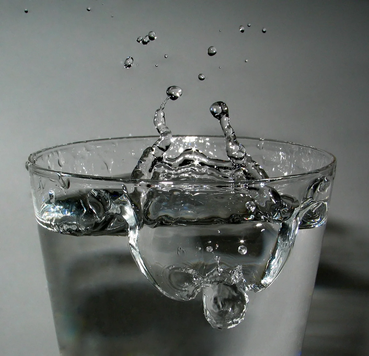 水滴撞击水面的真实摄影；拍摄光照影响画面颜色。